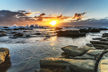 Fototapeta na wymiar Cloudy and Rocky Sunrise Seascape