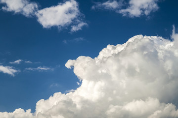 Blue sky with puffy white clouds in bright clear sunny day