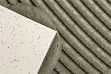 Close-up detail of floor tiles installation. Home improvement, renovation - ceramic tile floor adhesive, mortar.