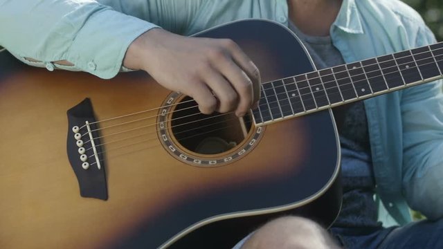 Man's hand strumming guitar