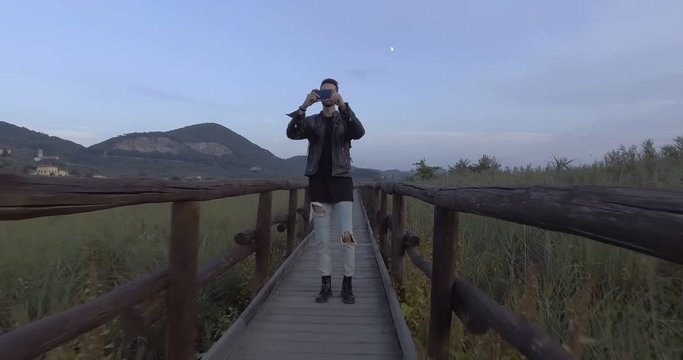Giovane ragazzo sta camminando su un ponte di legno in camapgana