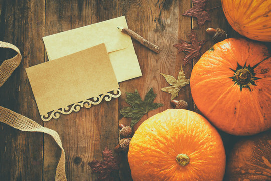 Pumpkins and autumn leaves on wooden background. thanksgiving and halloween concept. Top view