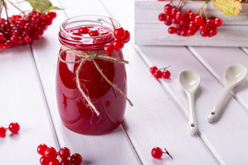 Delicious  viburnum jam with fresh berries on white table.