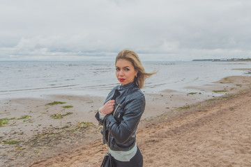 on a sandy beach on a cloudy day walking beautiful girl
