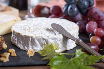 Famous French fresh soft cheese - camembert, delicious dessert with nuts and dried fruits