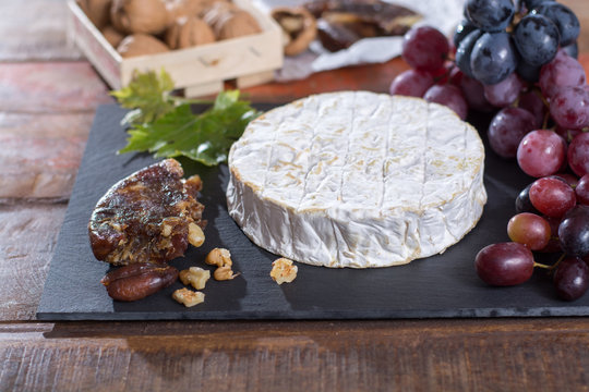 Famous French fresh soft cheese - camembert, delicious dessert with nuts and dried fruits