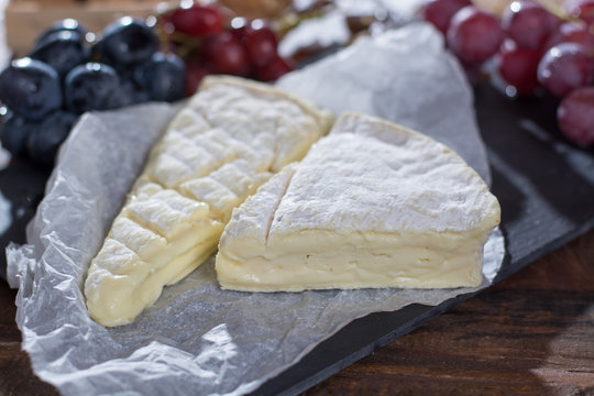 Famous French fresh soft cheese - brie, delicious dessert with nuts and dried fruits