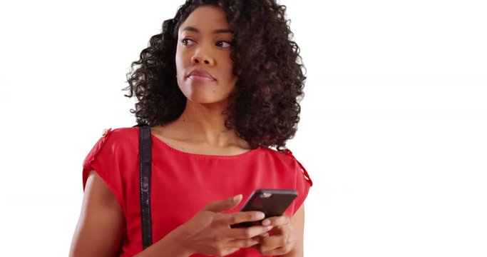 Portrait of pretty African female texting on cellphone in studio with copyspace
