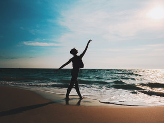 Silhouette of Young woman in casual style - denim and black top doing ballet at the beach....