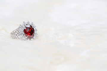 red gemstone on diamond ring