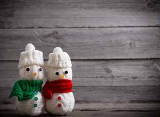Snowman toy on rustic wooden background