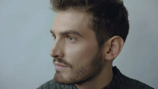 Close up profile of stylish handsome man looks aside on the background 4K