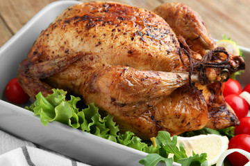 Baking tray with delicious roasted turkey on table
