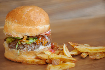 Tasty burger with french fries on wooden tray
