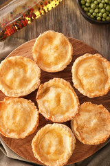 Board with delicious meat mini pies on table