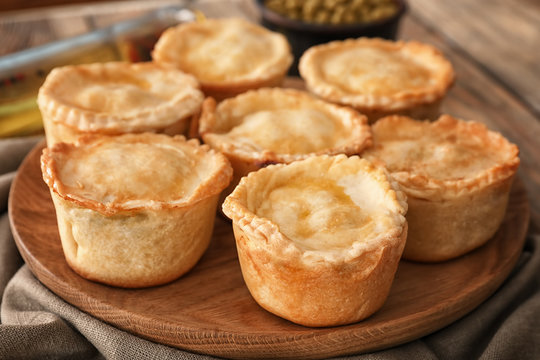 Delicious meat mini pies on wooden board