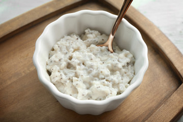 Bowl with delicious chia seed pudding on wooden board