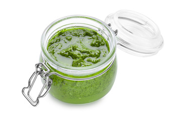 Jar with delicious basil pesto sauce on white background