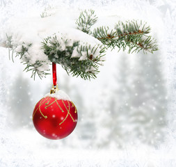 Fototapeta na wymiar Sprig of christmas tree (spruce) with of hanging ball in snow in of winter fir forest during snowfall with space for text.