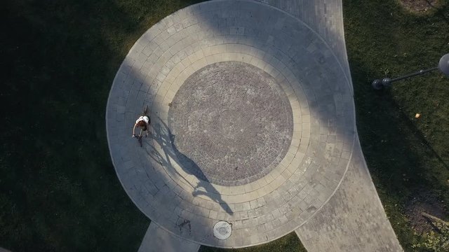 Top view bicycle woman riding a bike on round road in city park
