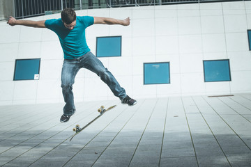 Junger Mann mit Skateboard, Stunt, Innenstadt