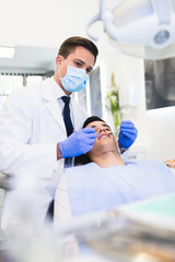 Young attractive man receiving a dental treatment. 