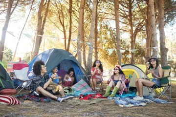 Young friends sitting together at campsite