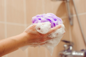 woman using a soap while taking shower in bathroom