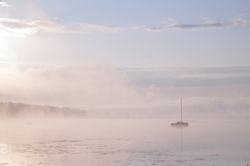 Fototapeta na wymiar Morning mist over lake with sailboat - 5