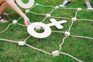 Big Tic Tac Toe game. Guy and girl playing outdoors.