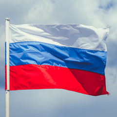 Russian flag against the sky. Flag of the Russian Federation. National symbol.