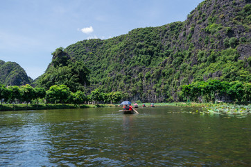 Fototapeta na wymiar Rowboats transporting tourists in Inland Haolong Bay, Ninh Binh, Vietnam.