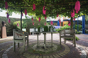 Pink clogs filled with flowers and apples hung on a tree to decorate the garden
