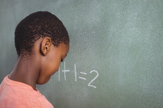 Boy standing by chalkboard