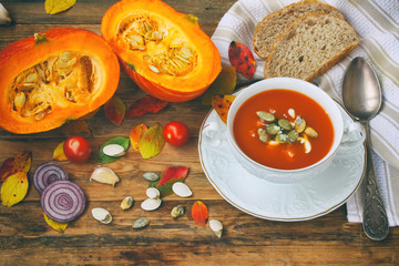 pumpkin soup puree in white bowl on wooden table