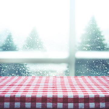 Checkered tablecloth texture top view with snowfall from window view background.For christmas decoration or new year concepts idea