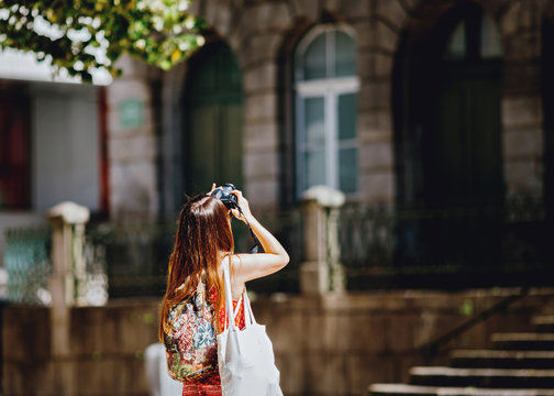 Young girl traveler photographing