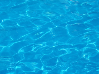 rippled that reflect sunlight on blue water surface in resort swimming pool