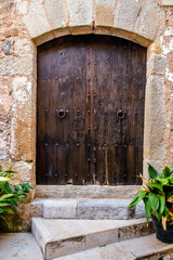 Fototapeta na wymiar A wooden door in the old part of Tossa de Mar,Spain