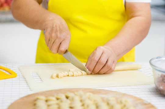 Close-up of woman's hand cut the dough