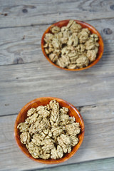 Obraz na płótnie Canvas Walnut kernels in brown bowls