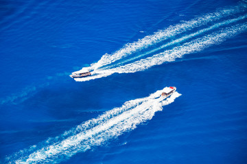Two motor boats going on high speed in blue sea