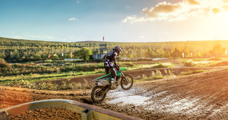 Naklejka na ściany i meble Extreme Motocross MX Rider riding on dirt track