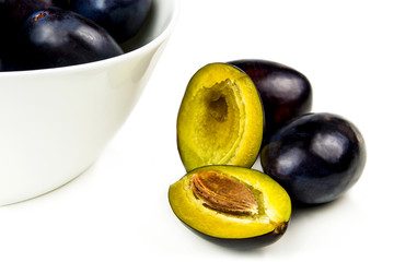 tasty plums in ceramic bowl