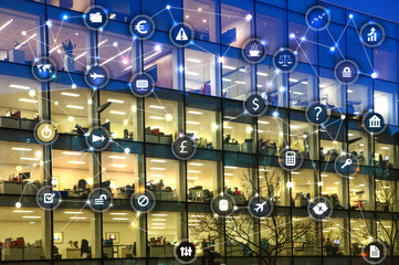 Night view of office windows City of London and business network connections concept. 