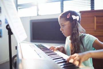 Concentrated elementary girl practicing piano