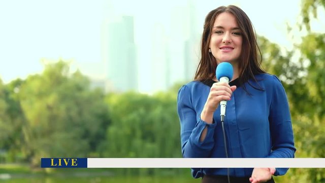 The journalist is reporting from the stadium for television with breaking news panel on screen