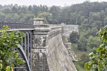 a dam connects to a bridge to span a valley to generate power by water