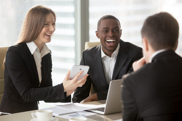 Happy smiling caucasian businesswoman using digital tablet at negotiations with multinational...