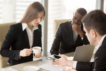 Pretty millennial businesswoman discussing terms of interesting business agreement with...